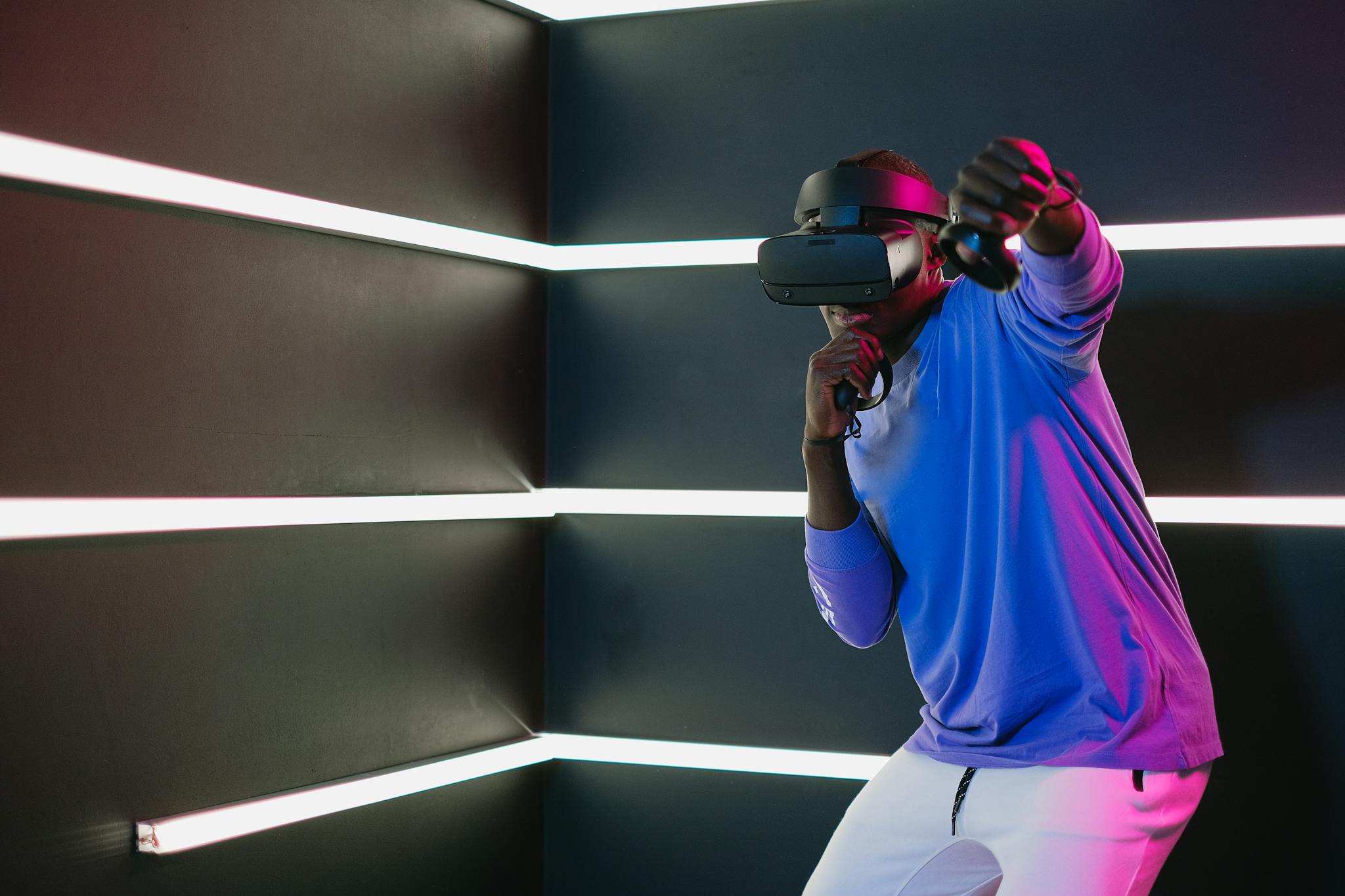 Man engaging in a virtual reality game with a headset and controllers.
